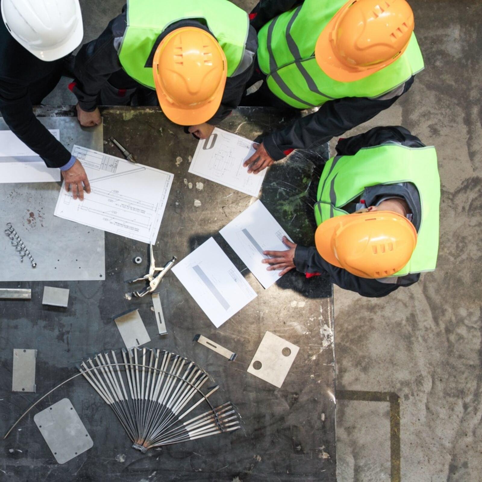 Project team discussing engineering drawings and project requirements